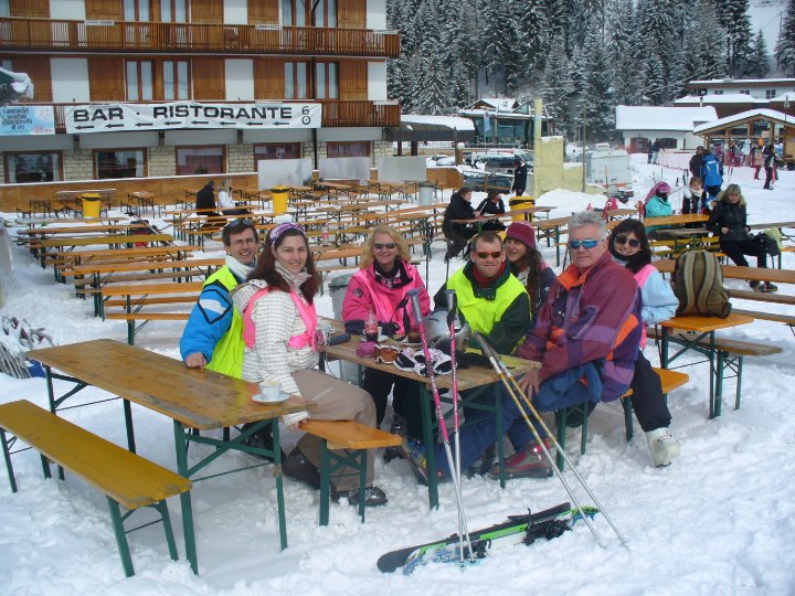 Group of people sat on benches in the snow.