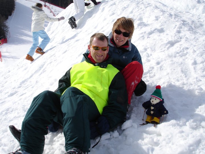 People sledging with a little woolly polar bear.