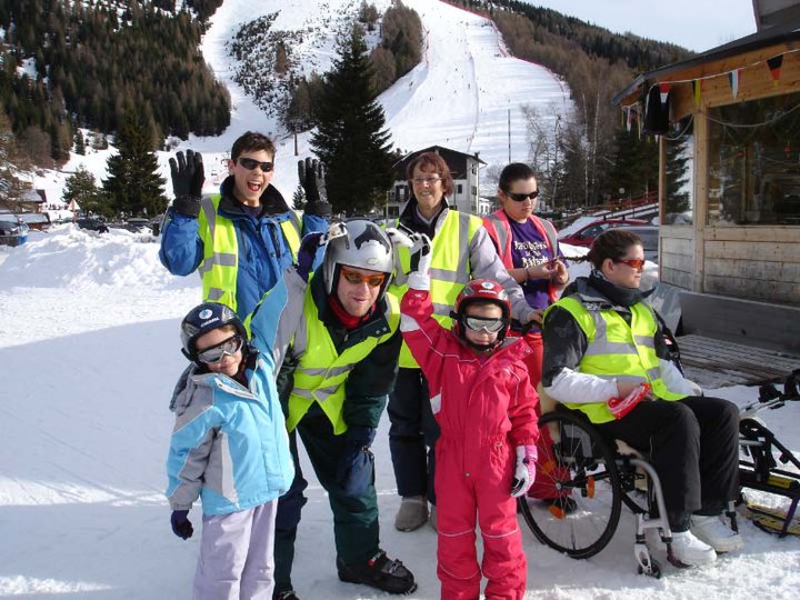 Group of disabled skiers waving and smiling.