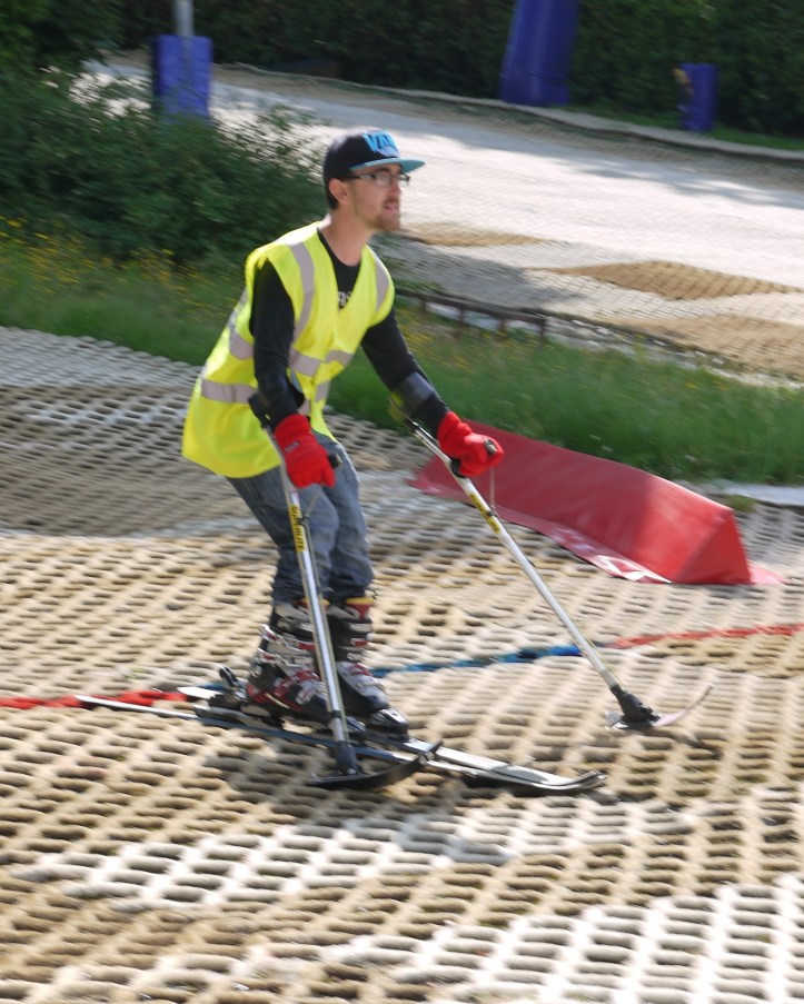 Man skiing using outriggers to help him balance and steer the skis.